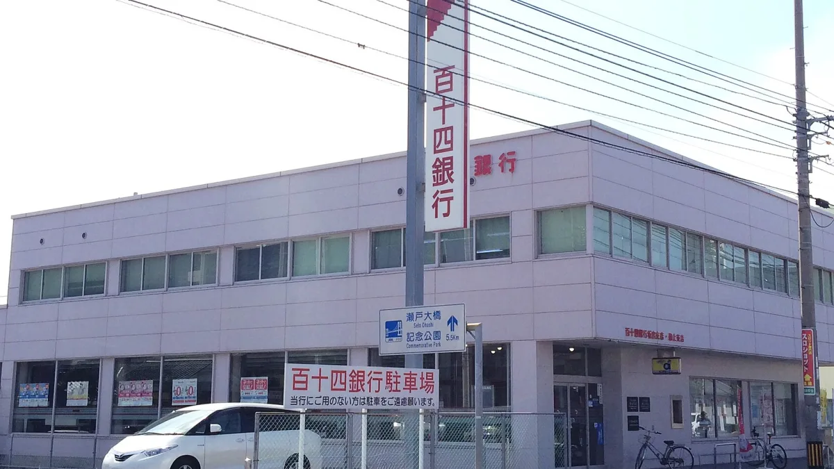 日本の地方銀行の支店。2階建ての建物と、縦長の看板が立っている